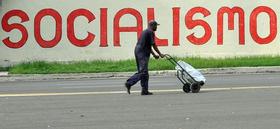 Un hombre camina frente a un cartel alusivo al socialismo, el jueves 13 de octubre de 2011, en La Habana