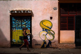 Una mujer camina junto a un mural en una calle de La Habana el 5 de diciembre de 2018