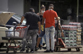 Varias personas colocan en un auto los productos que compraron de una tienda en dólares, el lunes 20 de julio de 2020, en La Habana, Cuba