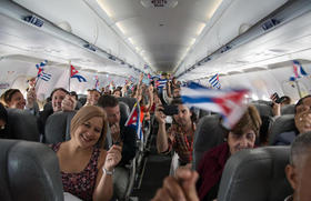 Pasajeros a bordo del vuelo #387 de JetBlue con destino a San Clara agitan banderitas cubanas y estadounidenses