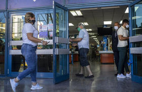 Compradores con mascarillas en medio de la pandemia entran a una tienda de alimentos que acepta dólares estadounidenses en La Habana, Cuba, el lunes 20 de junio de 2020, en esta foto de archivo