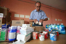 Un exiliado empaca alimentos en Miami, durante la recolecta de ayuda para enviar a la Isla