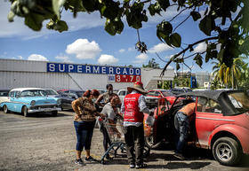 Varias personas colocan en un automóvil los productos que compraron de una tienda en dólares, el lunes 20 de julio de 2020, en La Habana, Cuba