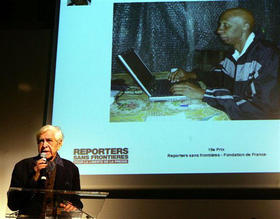 El exiliado Eduardo Manet muestra una imagen del periodista independiente Guillermo Fariñas, premiado por RSF, en París el 12 de diciembre de 2006.