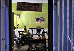 Un zapatero mantiene su taller privado abierto hasta la noche, en La Habana, Cuba