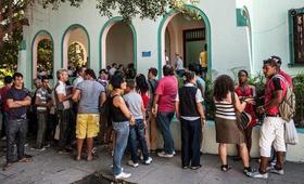 Cubanos hacen fila en una Oficina de Migración para solicitar un nuevo pasaporte, en La Habana
