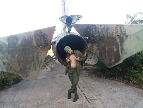 Soldado posando en la cola de otro MiG29 en ruinas