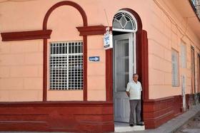 Un hombre permanece en la puerta de una casa particular donde se alquilan habitaciones a turistas, en La Habana, el martes 10 de mayo de 2011