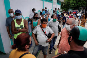 Cubanos en la fila y a la espera