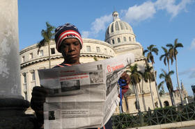 Un joven lee el diario 'Granma' en las cercanías del Capitolio de La Habana. (AFP)