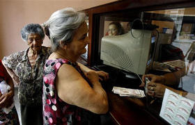 Una mujer recibe dinero en una oficina de correos en La Habana. (AP)