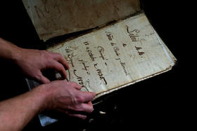 El estadounidense profesor de Historia David Lafevor sostiene un registro de la era colonial en la iglesia del Espíritu Santo, en La Habana Vieja, Cuba