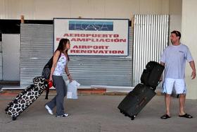 Una pareja de turistas extranjeros camina por una de las áreas en construcción del aeropuerto