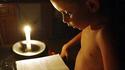 Niño cubano estudia a la luz de una vela durante un apagón