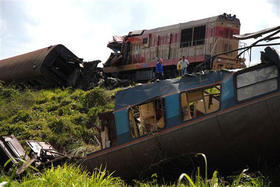 Residentes observan el estado de los trenes tras el accidente, en Camagüey, el 7 de febrero de 2009. (AP)