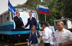 Visitantes pasan por un tren decorado con las imágenes de los gobernantes Raúl Castro y Vladimir Putin, el martes en las instalaciones de la XXXIV edición de la Feria Internacional de la Habana (FIHAV 2016)