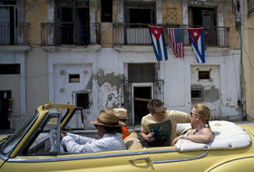 Foto de archivo de turistas paseando en un auto clásico en La Habana, Cuba