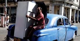 Un hombre transporta una refrigerador de fabricación china en un viejo automóvil en La Habana, Cuba, en esta foto de archivo