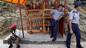 Dos agentes de la policía cubana vigilan desde una caseta artesanal en el poblado El Cobre, Santiago de Cuba