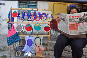 Una vendedora ambulante lee el diario oficial Granma, controlado por el Partido Comunista al igual que todos los medios nacionales. (AFP)