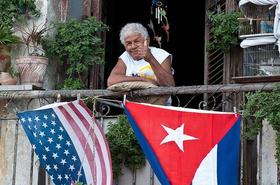 Una anciana en La Habana levanta su pulgar izquierdo, asomada en el balcón, adornado con banderas de Cuba y Estados Unidos, en esta foto de archivo