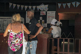 Clientes esperan en una tienda estatal mientras empleados cuentan dinero, en La Habana, el 31 de marzo de 2023