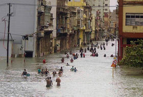 Varias personas caminan por una calle inundada en La Habana, Cuba, el 10 de septiembre de 2017, tras el paso del huracán Irma