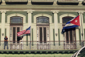 Un hombre de pie cerca de las banderas de EEUU y Cuba en el balcón del hotel Saratoga en La Habana, donde se alojaron los legisladores estadounidenses que recientemente visitaron la Isla, el 19 de enero de 2015