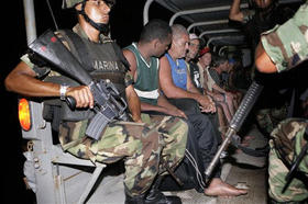 Cubanos escoltados por soldados mexicanos tras ser arrestados en Cancún