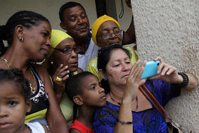 Un grupo de cubanos observa la llegada del presidente de EEUU, Barack Obama, a Cuba a través de la señal de televisión captada por un teléfono móvil, el domingo 20 de marzo de 2016 en La Habana. Un grupo de cubanos observa la llegada del presidente de EEUU, Barack Obama, a Cuba a través de la señal de televisión captada por un teléfono móvil, el domingo 20 de marzo de 2016 en La Habana