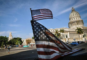 Una bandera de Estados Unidos ondea en un bicitaxi en La Habana, con el Capitolio Nacional al fondo