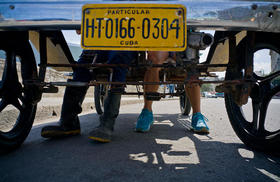 Dany Gómez, derecha, y un amigo descansan los pies después de pedalear desde su casa al Malecón en La Habana, Cuba, 20 de febrero de 2017