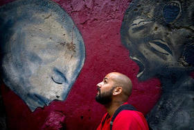 El grafitero Yulier Rodríguez Pérez posa con una de sus obras, pintada en una pared de La Habana Vieja, Cuba, el 9 de febrero de 2017