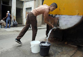 Un cubano se abastece del agua distribuida por un camión cisterna. Jorge Luis Baños/IPS