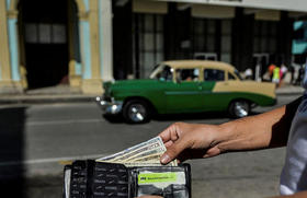 Un hombre muestra su billetera con dólares estadounidenses en una calle de La Habana, el 15 de septiembre de 2020
