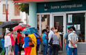 Varias personas hacen fila para entrar en un banco en La Habana