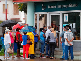 Varias personas hacen fila para entrar en un banco en La Habana