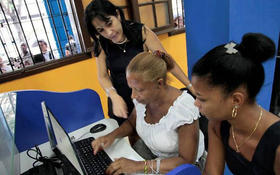 Una empleada de la compañía de telecomunicaciones Etecsa ayuda a una mujer en uno de los centros públicos para la restringida Internet en la Isla