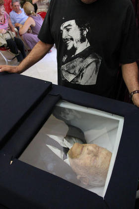 Un hombre observa el cuerpo de Alberto Granado, amigo y compañero del guerrillero Ernesto "Che" Guevara en su viaje de juventud en motocicleta por Suramérica, quien falleció el sábado 5 de marzo de 2011, en La Habana, a la edad de 88 años