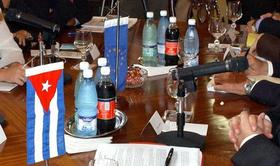 Mesa de negociaciones con banderas de la Unión Europea y Cuba