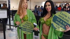 Las damas lechuga de PETA Kiara Benac (izquierda) y Yerika Sojo (derecha), se disponen a abordar su vuelo a Cuba