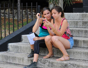 Cubanas utilizan un teléfono móvil o celular