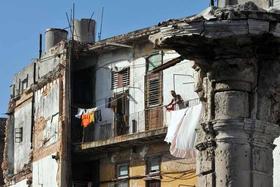 Una mujer tiende la ropa en un balcón de su casa en La Habana (Cuba), el jueves 3 de noviembre de 2011, día en que Granma anunció que Cuba pondrá en vigor a partir del 10 de noviembre nuevas normas que permitirán la compraventa de viviendas entre particulares tras décadas de prohibiciones