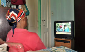 Una cubana ve un programa de televisión que emite imágenes del encuentro sostenido el pasado martes entre Fidel Castro y Hugo Chávez