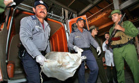 Policías y guardias costeros cubanos descargan 25 sacos de marihuana, en febrero de 2005, en Las Tunas, Cuba