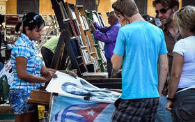 Turistas miran carteles en venta en una librería de uso callejera en La Habana Vieja en diciembre del 2014