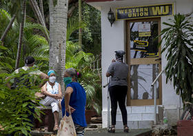 Varias personas permanecen afuera de una oficina de Western Union el viernes 12 de junio de 2020 en el vecindario Vedado de La Habana, Cuba