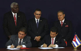 El nuevo presidente de El Salvador, Mauricio Funes (centro), durante la firma del restablecimiento de relaciones entre su país y Cuba. Junto a él, el vicepresidente cubano Esteban Lazo (izq) y vicepresidente salvadoreño, Salvador Sánchez Ceren (der). San Salvador, 1 de junio de 2009. (AP)