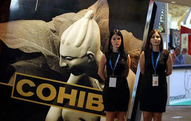 Dos promotoras posan cerca de una publicidad de Cohíba durante la XXX Feria Internacional de La Habana, en noviembre de 2012