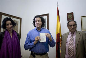 El cardiólogo Norberto Díaz (al centro) muestra su pasaporte español. La Habana, 5 de febrero de 2008. (AP)